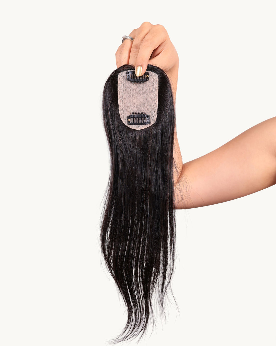 The smallest hair topper held by a hand to show the scalp